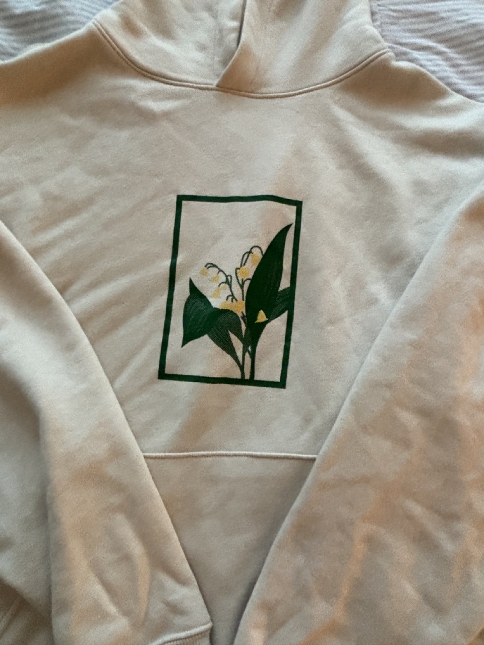 Photograph of the 2 color screen printed design on a beige hoodie.